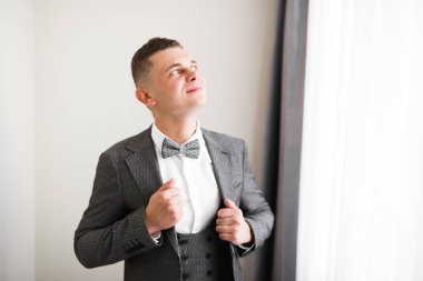 Güzel adam, damat poz veriyor ve düğüne hazırlanıyor.