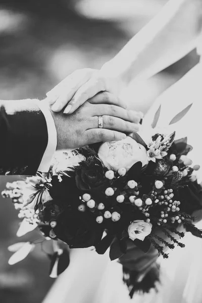 Hermosa joven pareja de boda posando con ramo de flores en las manos —  Fotos de Stock