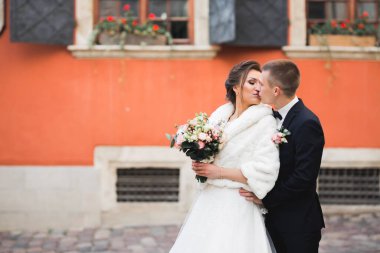 Güzel gelin ve damat düğün günlerinde kucaklaşıp öpüşürler.