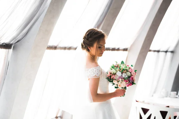 Portret van een prachtige bruid met lang haar poseren met grote boeket — Stockfoto