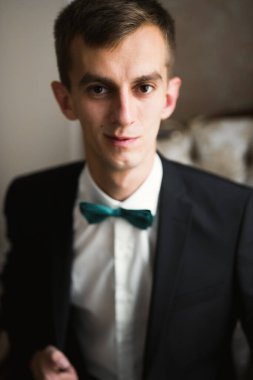 Güzel adam, damat poz veriyor ve düğüne hazırlanıyor.