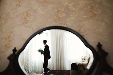 Güzel adam, damat poz veriyor ve düğüne hazırlanıyor.