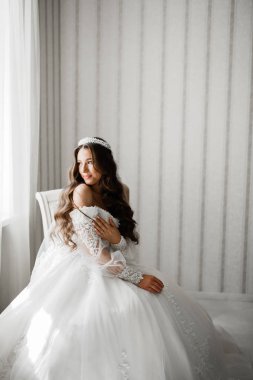 Beyaz elbiseli lüks gelin düğün törenine hazırlanırken poz veriyor.