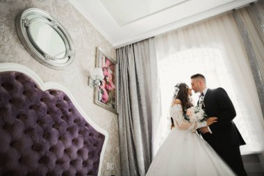 Güzel, genç bir çift ellerinde çiçeklerle poz veriyorlar.