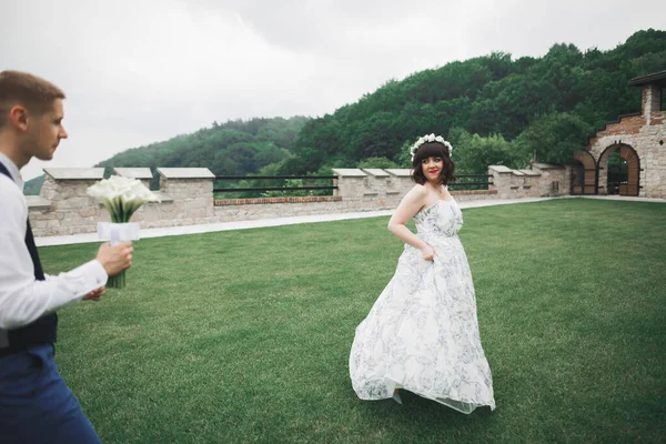 Romantic wedding moment, bride running from groom in a park — ストック写真