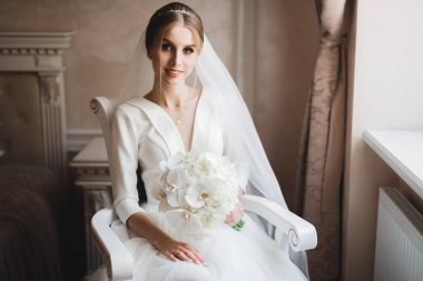 Gelin çiçekli büyük ve güzel bir düğün buketi tutuyor.