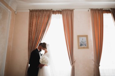 Güzel, genç bir çift ellerinde çiçeklerle poz veriyorlar.