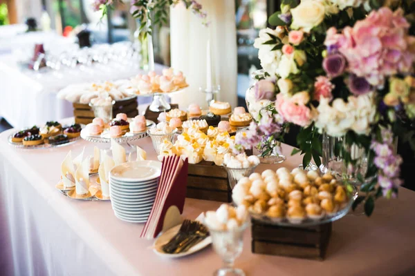 Deliziosi dolci sul buffet di caramelle nuziali con dessert, cupcake — Foto Stock