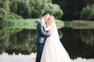 Romantik düğün anı, yeni evli çiftin gülümseyen portresi, gelin ve damadın kucaklaşması