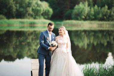 Romantik düğün anı, yeni evli çiftin gülümseyen portresi, gelin ve damadın kucaklaşması