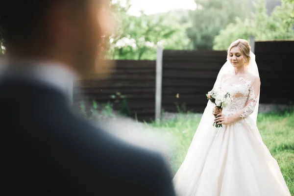 Красивая роскошная молодая невеста в свадебном платье позирует в парке — стоковое фото