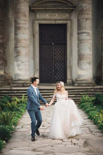 Fotografia de casamento. Noiva e noivo andando na cidade. Casal casal abraçando e olhando um para o outro — Fotografia de Stock