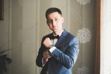 Güzel adam, damat poz veriyor ve düğüne hazırlanıyor.