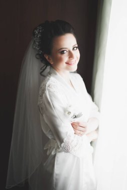 Beyaz elbiseli lüks gelin düğün törenine hazırlanırken poz veriyor.