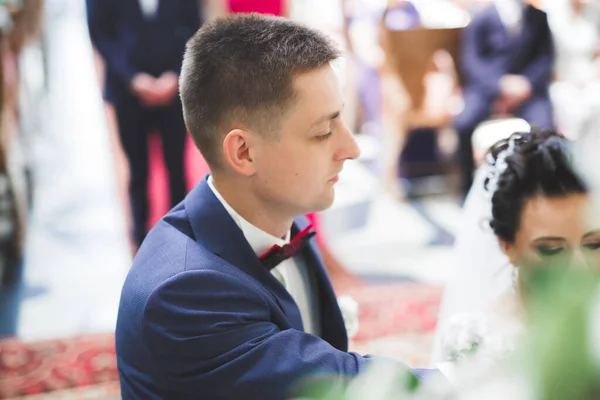 Pareja casada posando en una iglesia después de la ceremonia — Foto de Stock