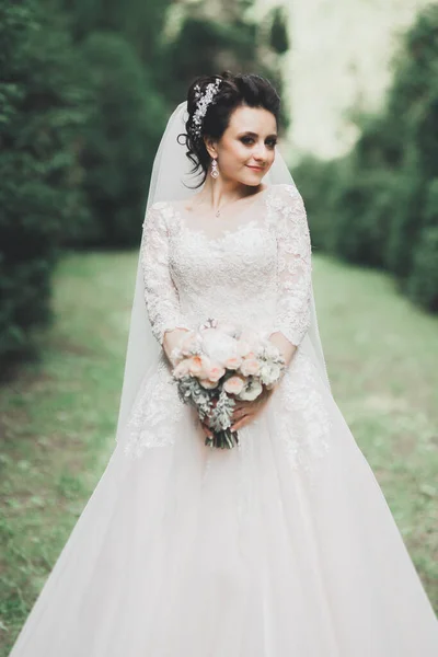 Retrato de novia impresionante con el pelo largo posando con gran ramo — Foto de Stock