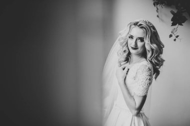 Beyaz elbiseli lüks gelin düğün törenine hazırlanırken poz veriyor.