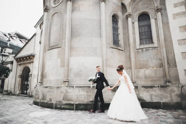 Muhteşem düğün çifti eski şehirde yürüyor. — Stok fotoğraf