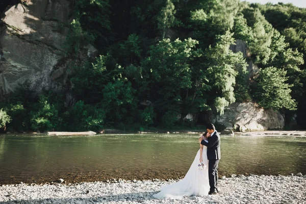 Matrimonio coppia, sposo e sposa abbracciare, all'aperto vicino al fiume — Foto Stock