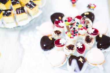 Lezzetli ve tatlı bir tatlı masası. Kapalı resepsiyonda küçük kekler ve shot 'lar var.