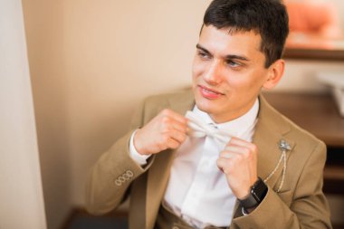 Güzel adam, damat poz veriyor ve düğüne hazırlanıyor.