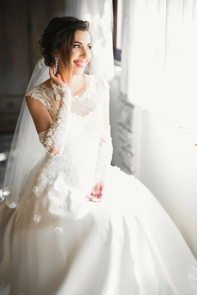 Noiva de luxo em vestido branco posando enquanto se prepara para a cerimônia de casamento — Fotografia de Stock