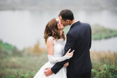 Güzel gelin ve damat evlendikleri gün kucaklaşıp öpüşüyorlar.