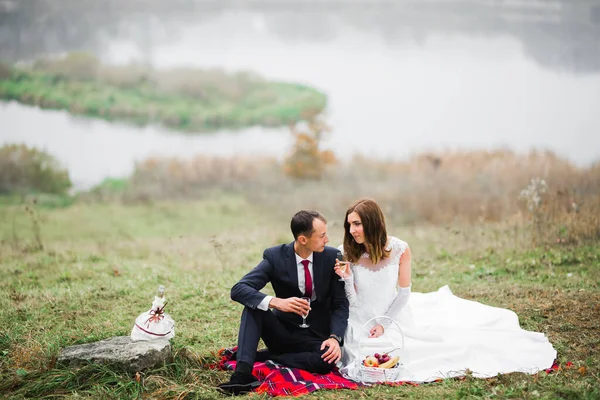 Lächelndes Hochzeitspaar klirrt mit Champagnergläsern — Stockfoto