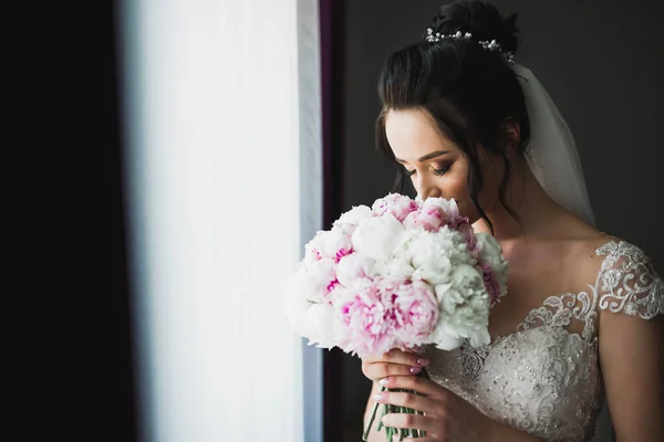 Portrait of stunning bride with long hair posing with great bouquet — Stock Photo, Image