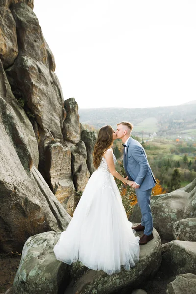 Beautiful bride and groom embracing and kissing on their wedding day outdoors — Stock Photo, Image