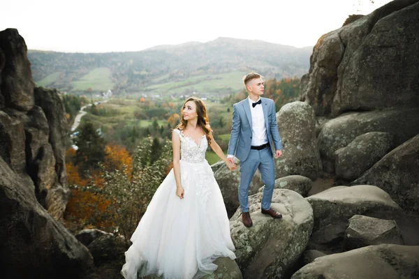 Beautiful gorgeous bride posing to groom and having fun near at mountains with amazing view, space for text, wedding couple — Stock Photo, Image