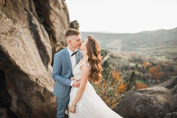 Krásná nádherná nevěsta pózuje ženich a baví v blízkosti hor s úžasným výhledem, prostor pro text, svatební pár — Stock fotografie