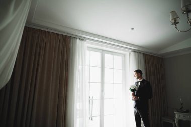 Genç ve yakışıklı bir adam iş toplantısından sonra bir otelde dinleniyor.