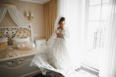 Tüylü, lüks makyaj, saç stili, stüdyo içi fotoğraf çekimi olan güzel bir gelin.