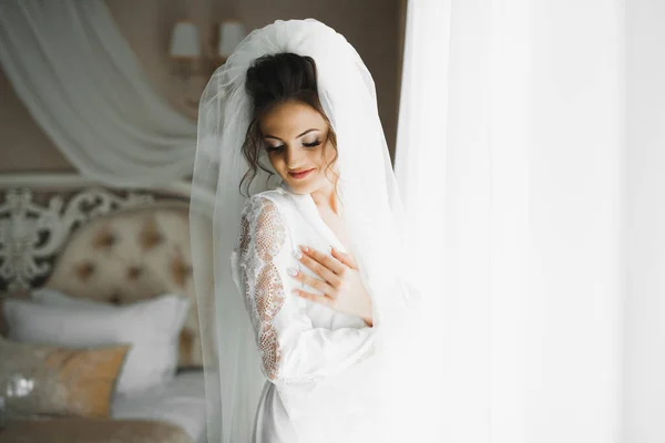 Чудова наречена в халаті позує і готується до весільної церемонії обличчя в кімнаті — стокове фото