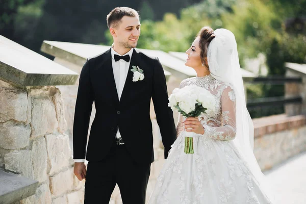 Joyeux couple de mariage marchant dans un parc botanique — Photo