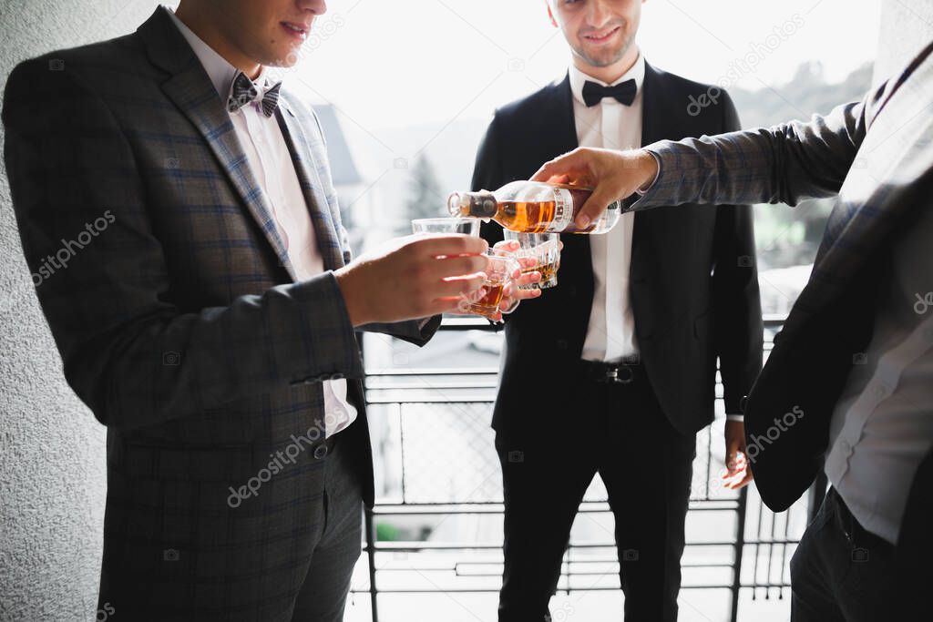 Business meeting. Men hold glasses of whiskey. Mens Party. Hand with a drink of alcohol