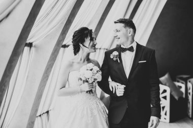 Göz kamaştırıcı mutlu çift birbirine yakın duruyor ve gözlerinin içine bakıyor.