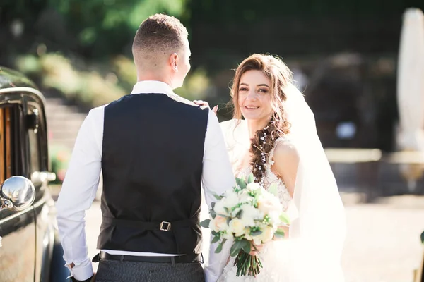 Wedding bride and groom, elegant couple staying near retro wedding car — Stock Photo, Image