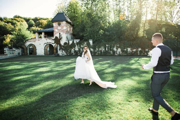 Joyeux couple de mariage marchant dans un parc botanique — Photo