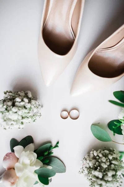 結婚指輪とバラや他の花の花束とエレガントでスタイリッシュなブライダルシューズのペア — ストック写真