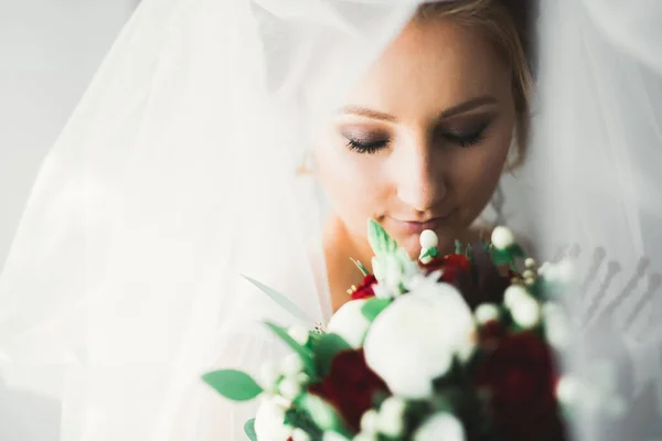 Vacker lyx brud i elegant vit klänning håller bukett med blommor i händerna — Stockfoto