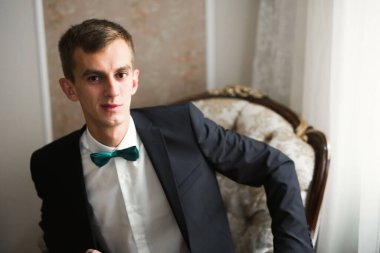 Güzel adam, damat poz veriyor ve düğüne hazırlanıyor.