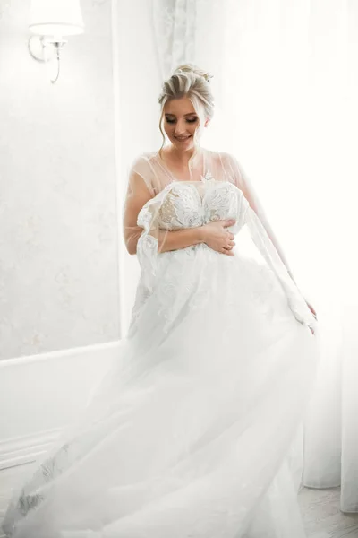 Noiva de luxo em vestido branco posando enquanto se prepara para a cerimônia de casamento — Fotografia de Stock