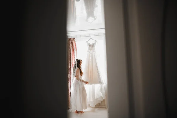 Noiva de luxo em vestido branco posando enquanto se prepara para a cerimônia de casamento — Fotografia de Stock