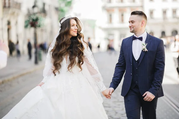 Ein liebenswertes Hochzeitspaar geht zurück durch die Straßen der Stadt Lviv — Stockfoto