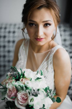 Gelin çiçekli büyük ve güzel bir düğün buketi tutuyor.