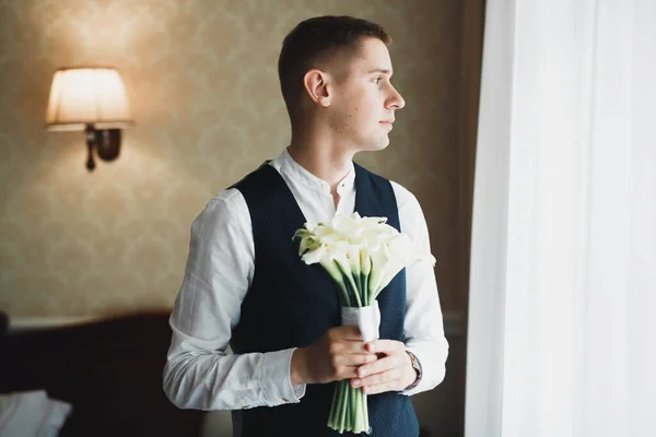 Homem bonito, noivo segurando grande e bonito buquê de casamento com flores — Fotografia de Stock