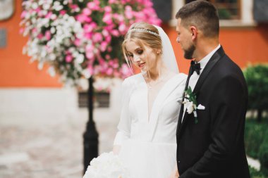 Güzel, mutlu bir düğün çifti, güzel şehirde uzun beyaz elbiseli bir gelin.