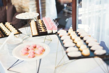 Lezzetli ve tatlı bir tatlı masası. Kapalı resepsiyonda küçük kekler ve shot 'lar var.